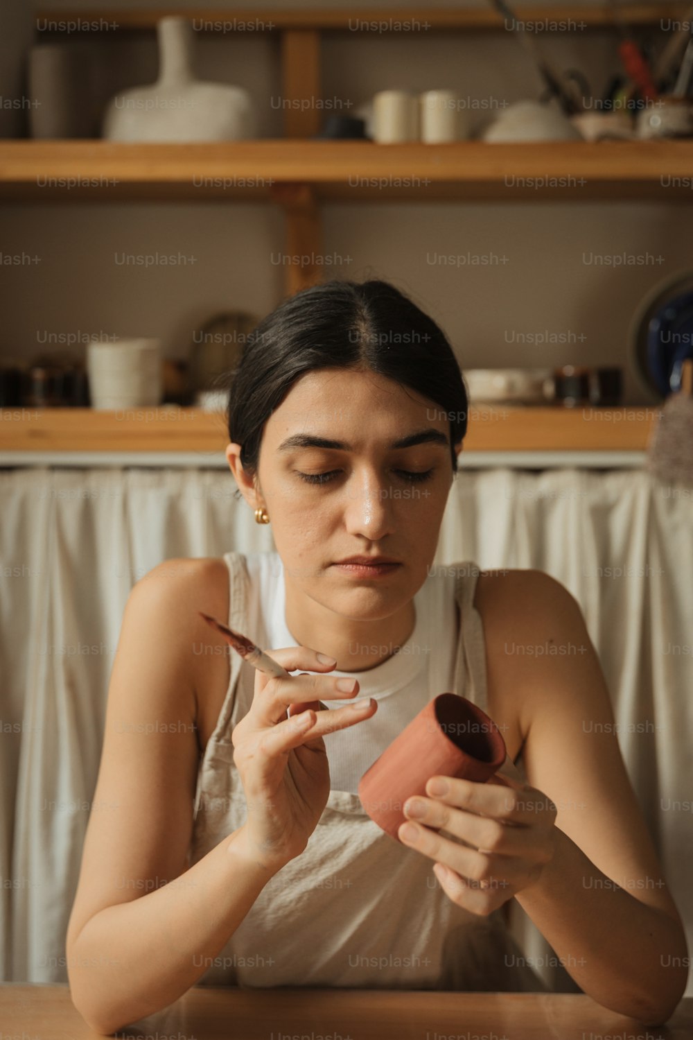 a woman sitting at a table holding a piece of paper