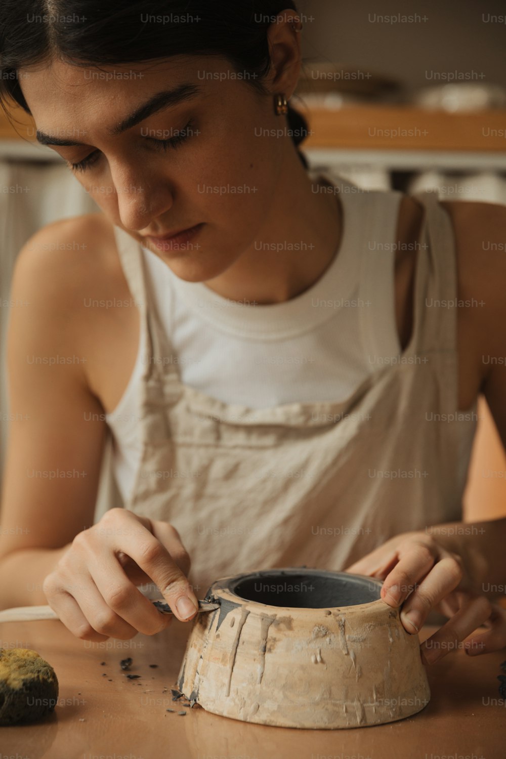 Una donna in camicia bianca sta facendo un vaso