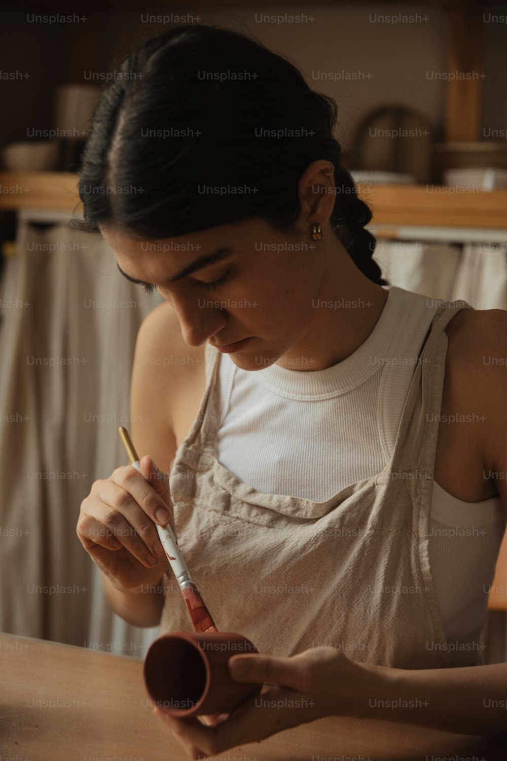 a woman in a white tank top writing on a piece of paper