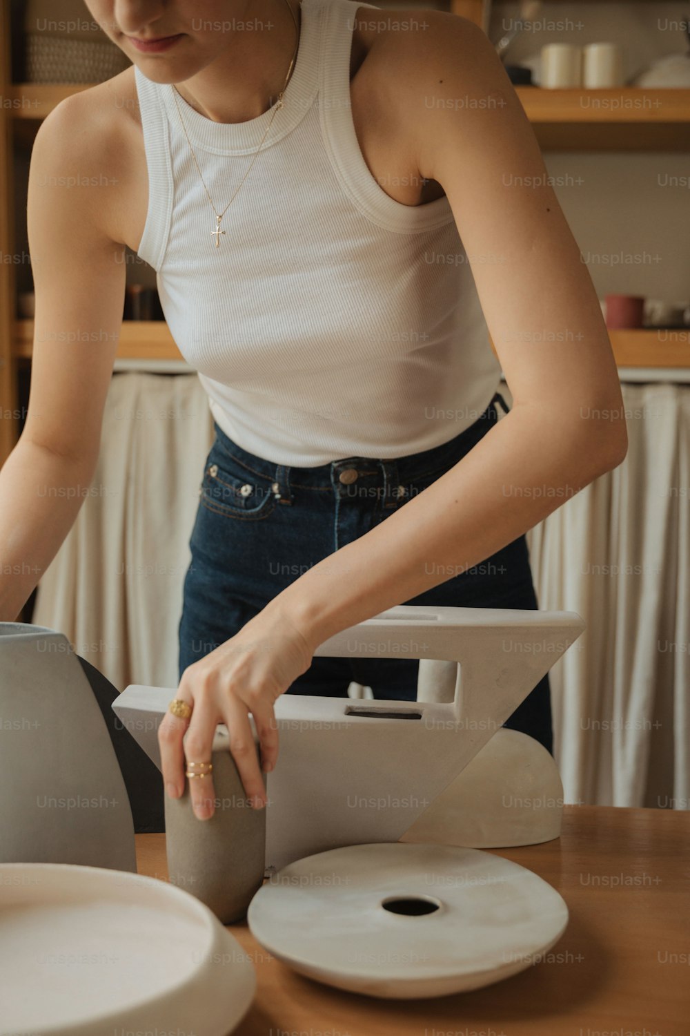 a woman in a white tank top is using a paper towel dispenser