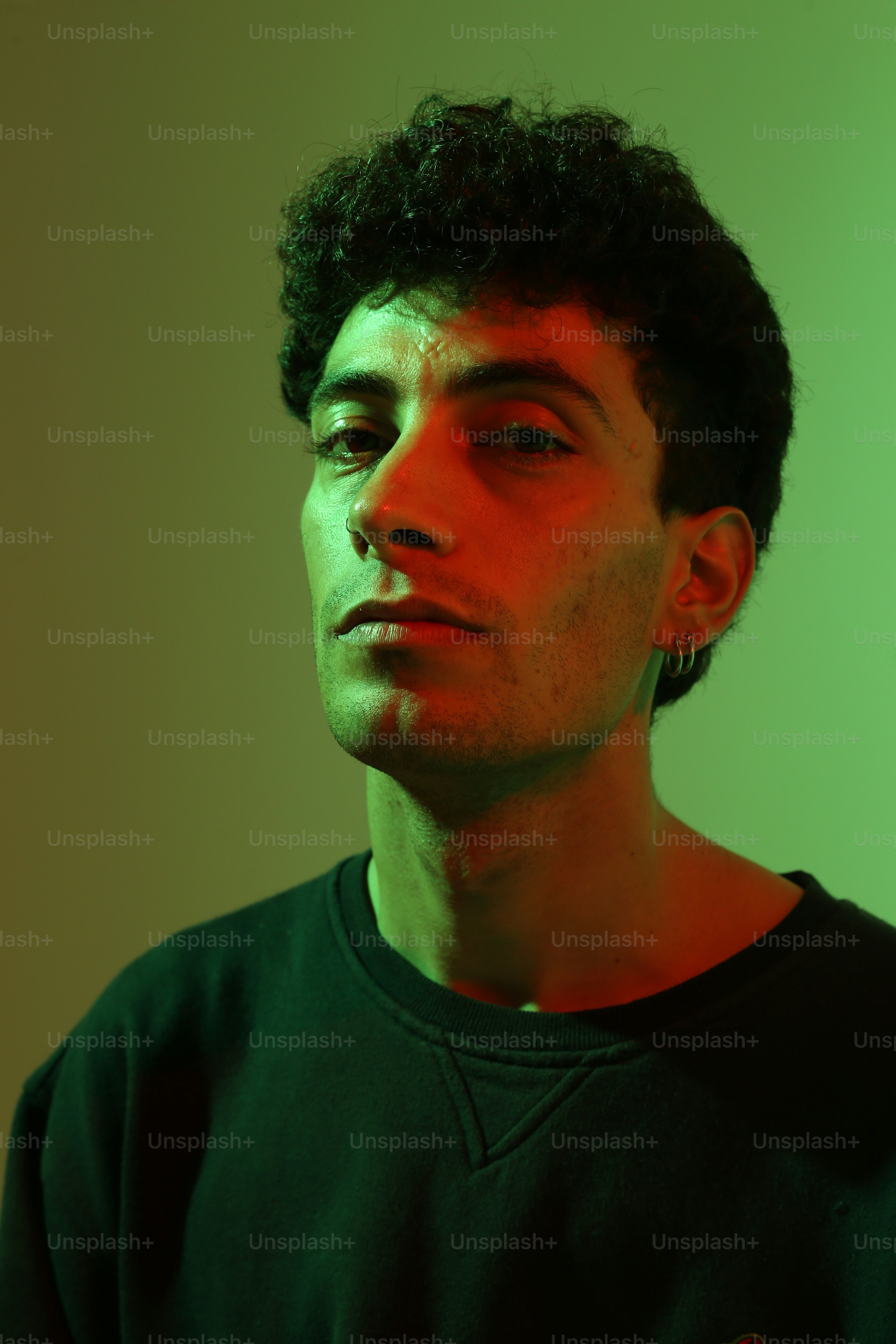 緑のシャツを着た男が何かを見つめている