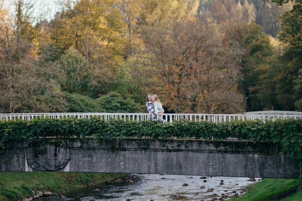 a couple of people that are standing on a bridge