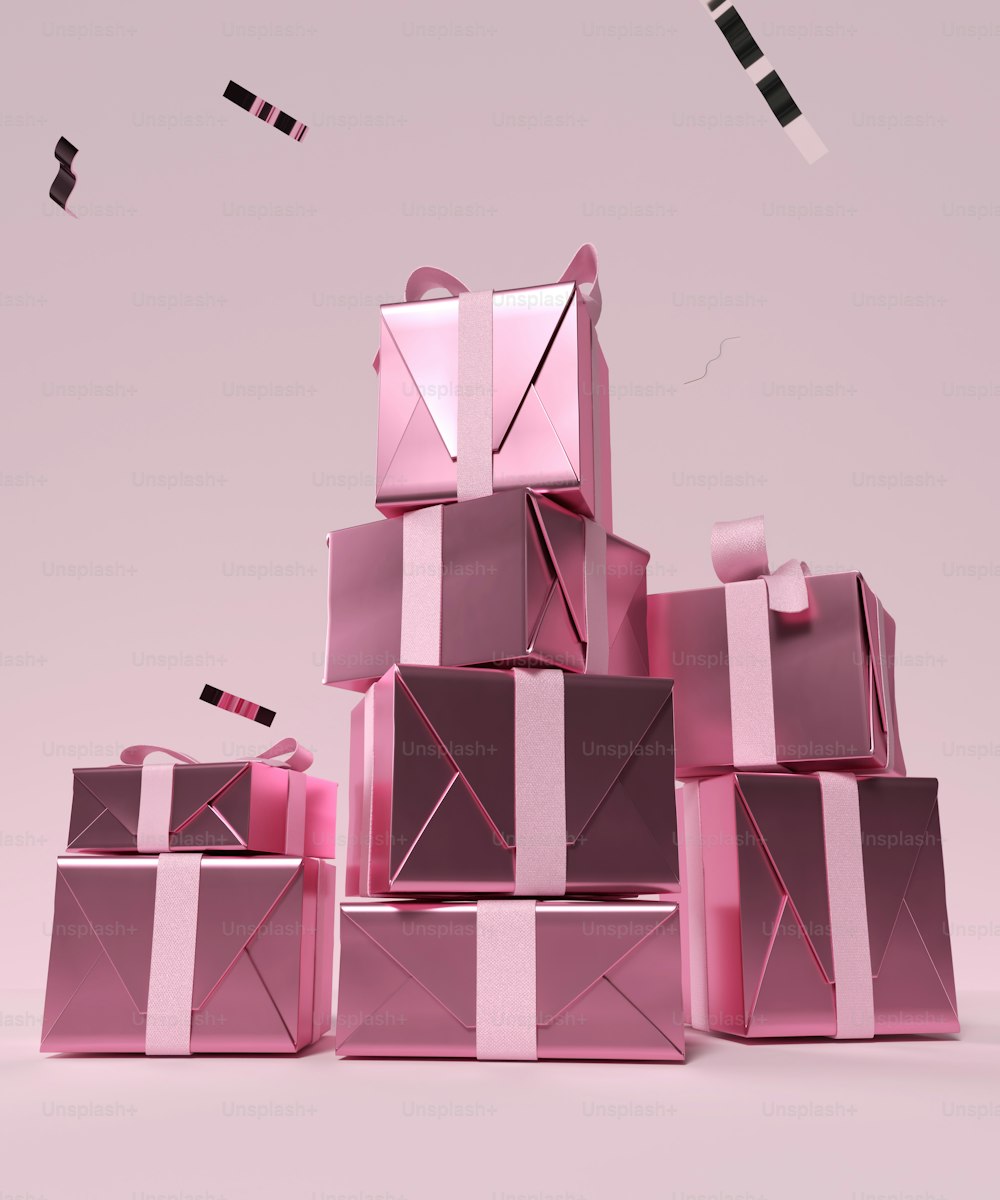 uma pilha de caixas cor-de-rosa com fitas sobre elas