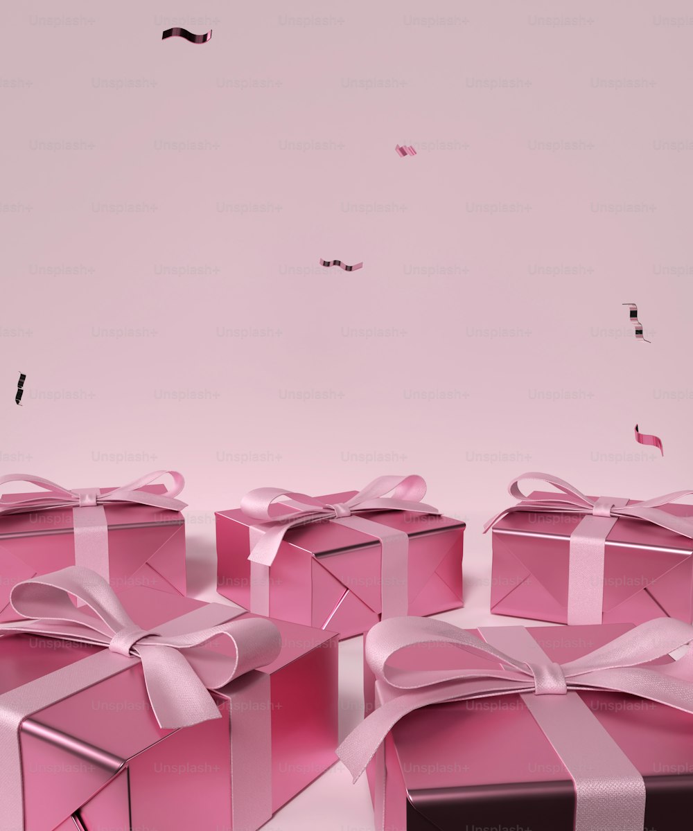 Un grupo de cajas de regalo rosas con lazos