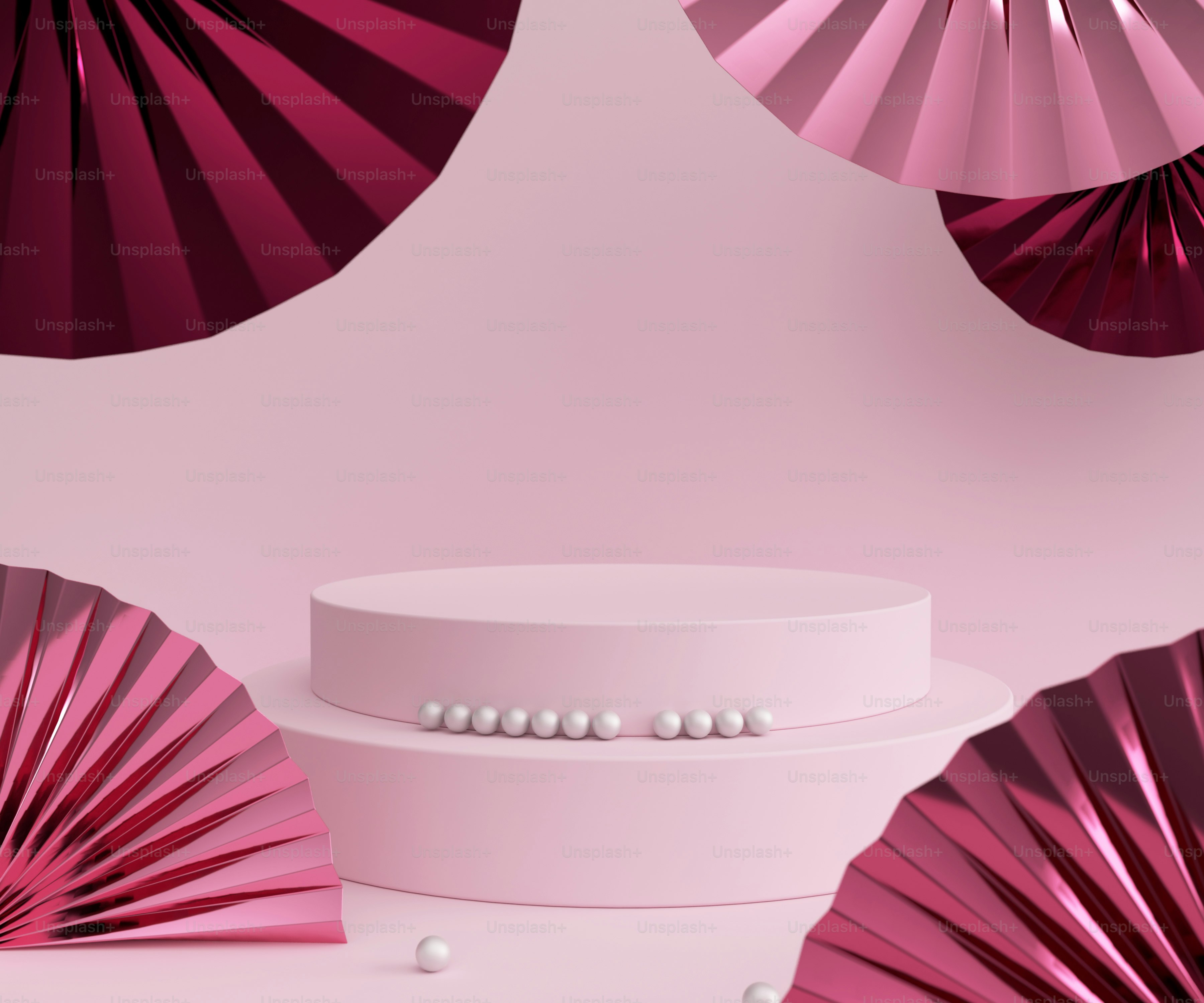 a white cake with pink paper fans behind it