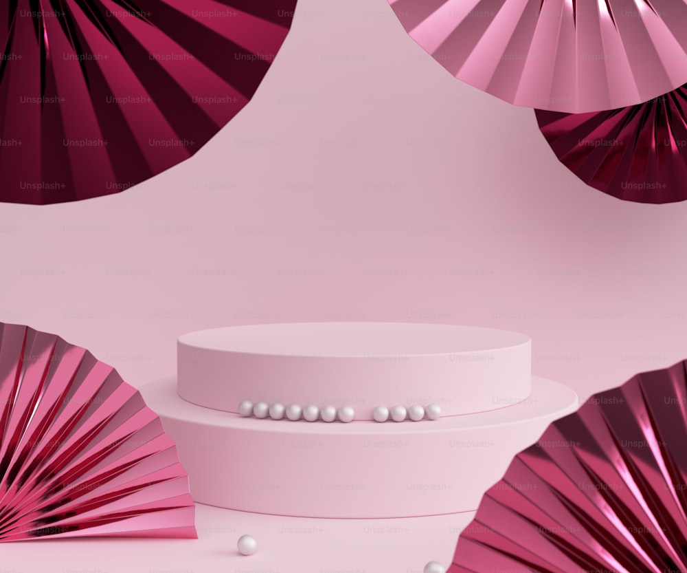 Un pastel blanco con abanicos de papel rosa detrás