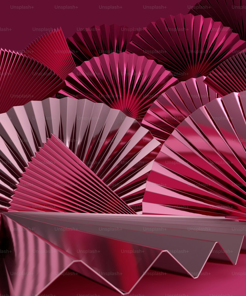 a group of pink paper fans sitting on top of a table