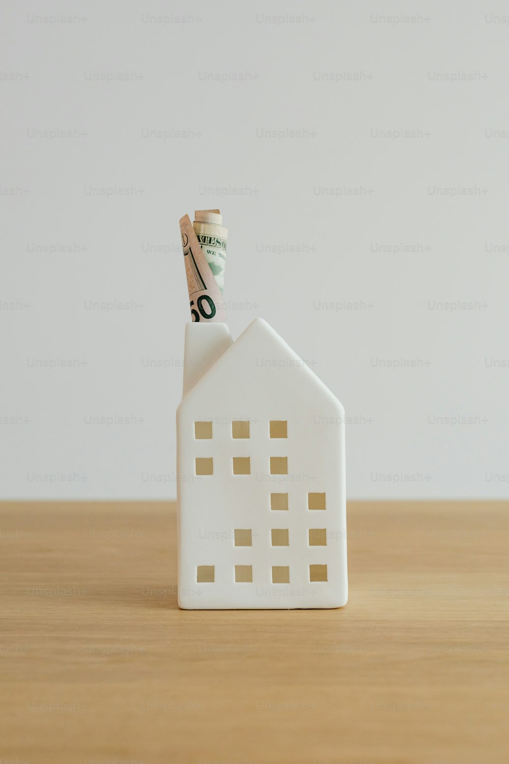 a house shaped money holder on a wooden table