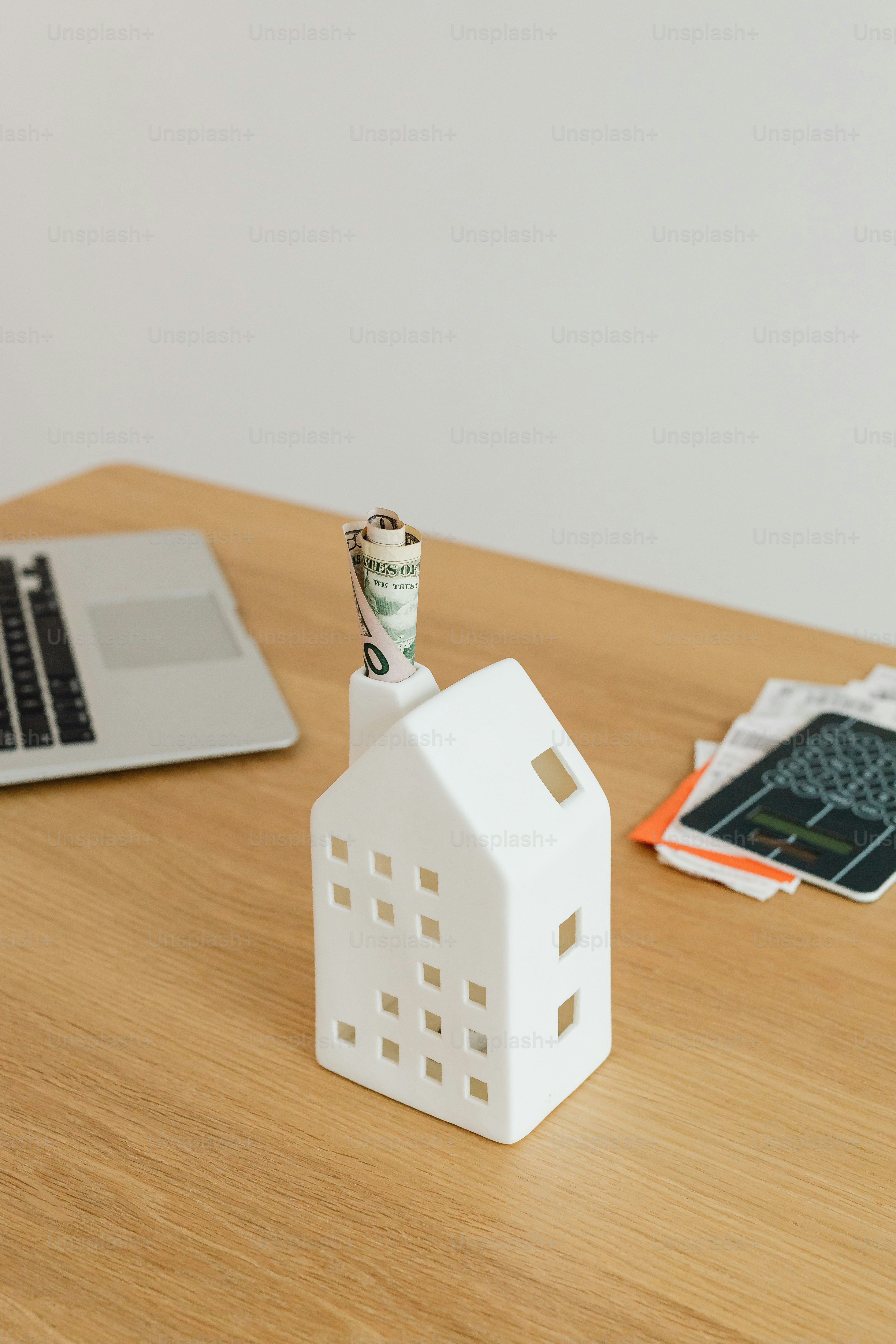 a small white house sitting on top of a wooden table