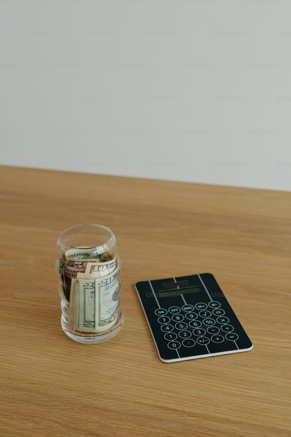 a glass of water and a calculator on a table