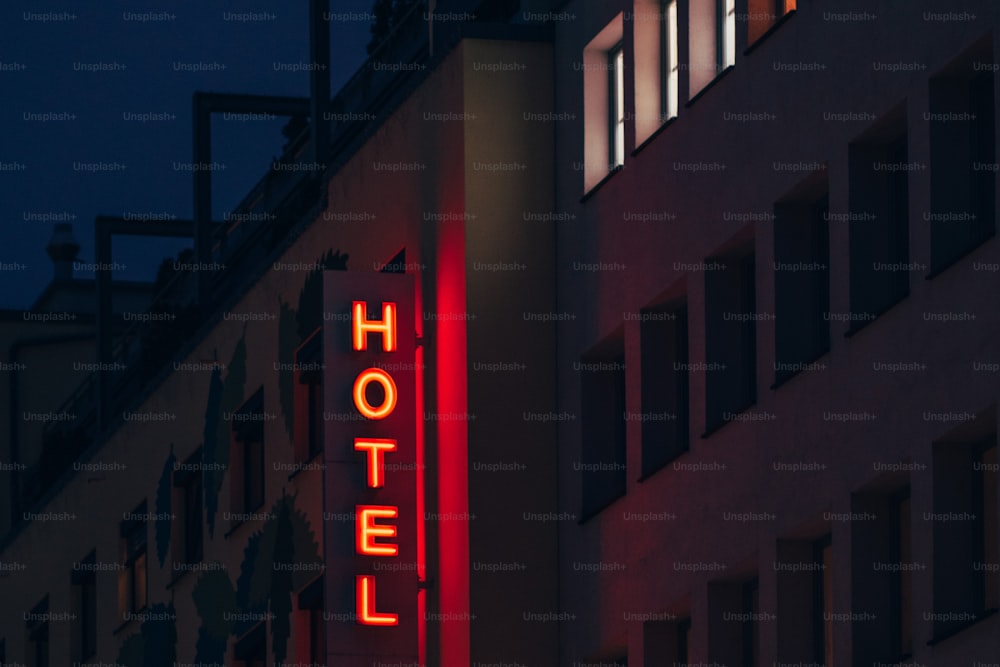 uma placa de hotel iluminada à noite em um prédio