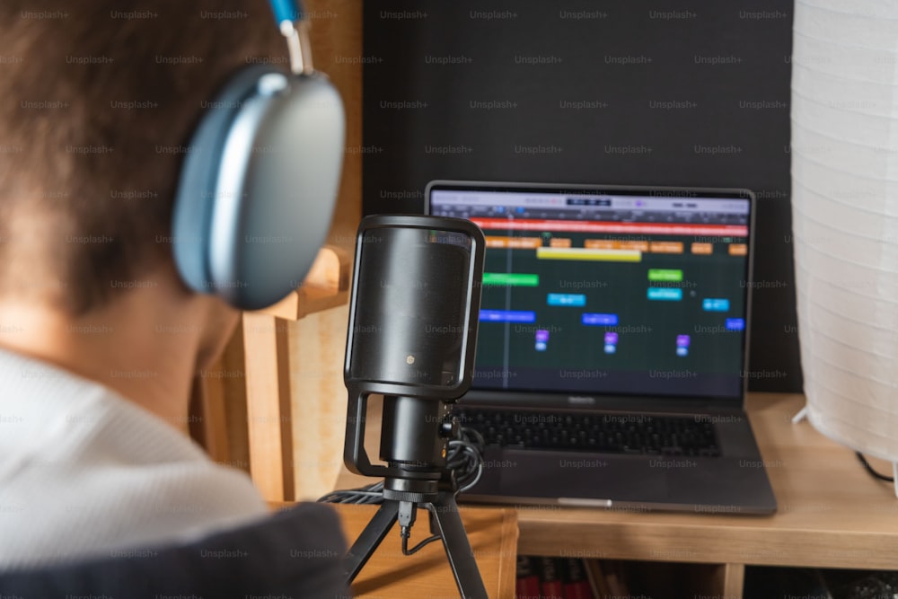 a man wearing headphones is looking at a laptop