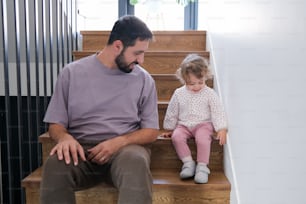 Un hombre y una niña sentados en un conjunto de escaleras