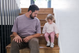 a man and a little girl sitting on a set of stairs