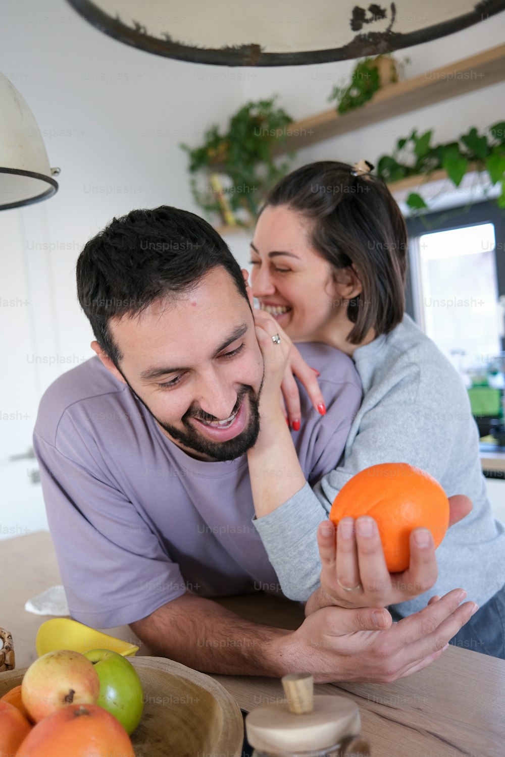 a man holding a woman in his arms in a kitchen