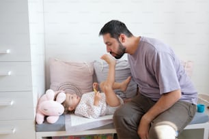 a man sitting on a bed next to a baby
