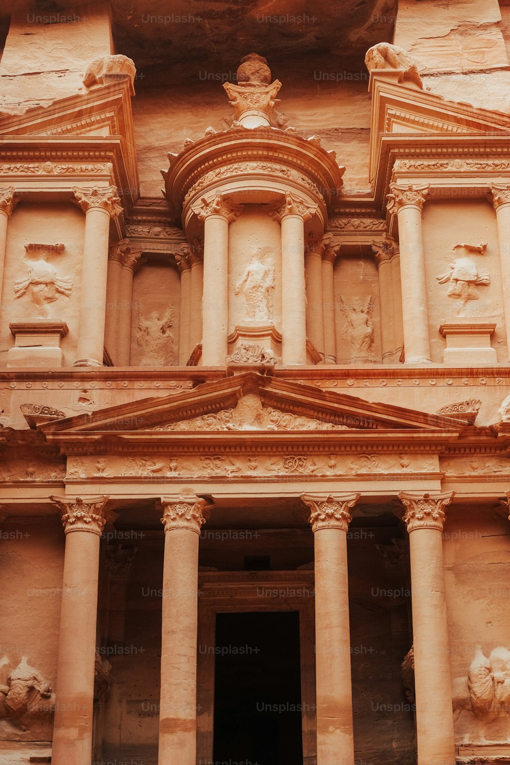 a tall building with columns and statues on the side of it