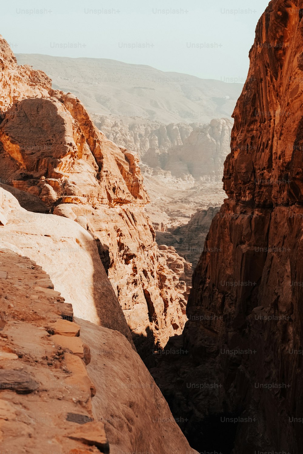 a man standing on top of a mountain next to a cliff