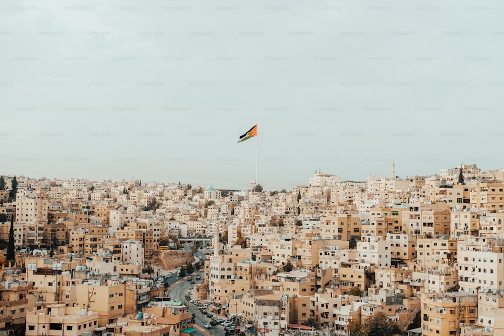 a kite flying over a city filled with tall buildings