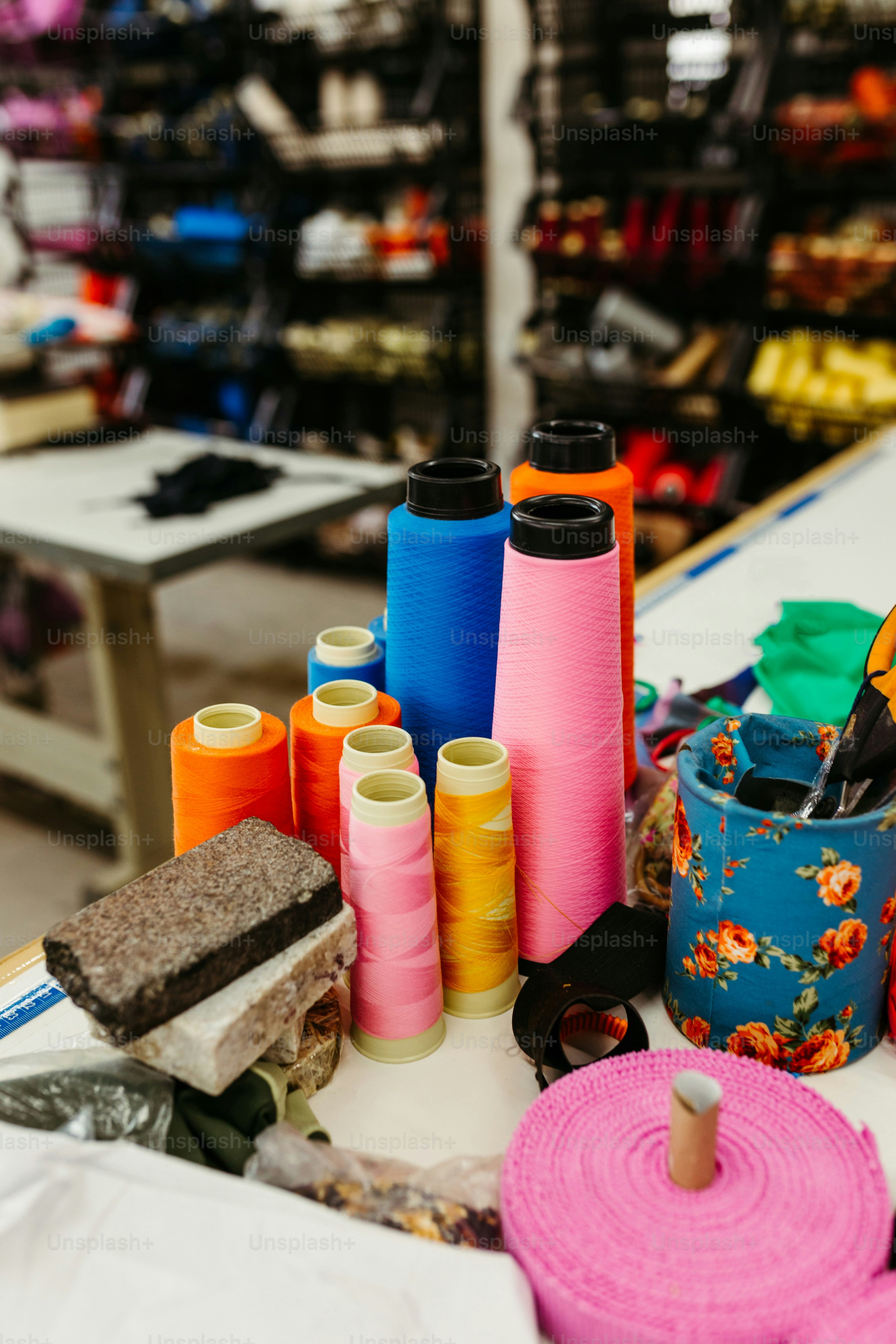 a table topped with lots of different colored spools of thread