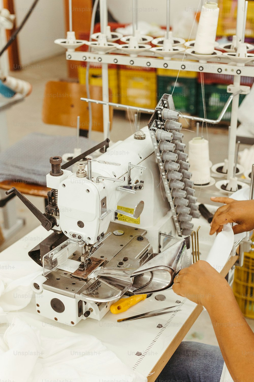 Una mujer está trabajando en una máquina de coser