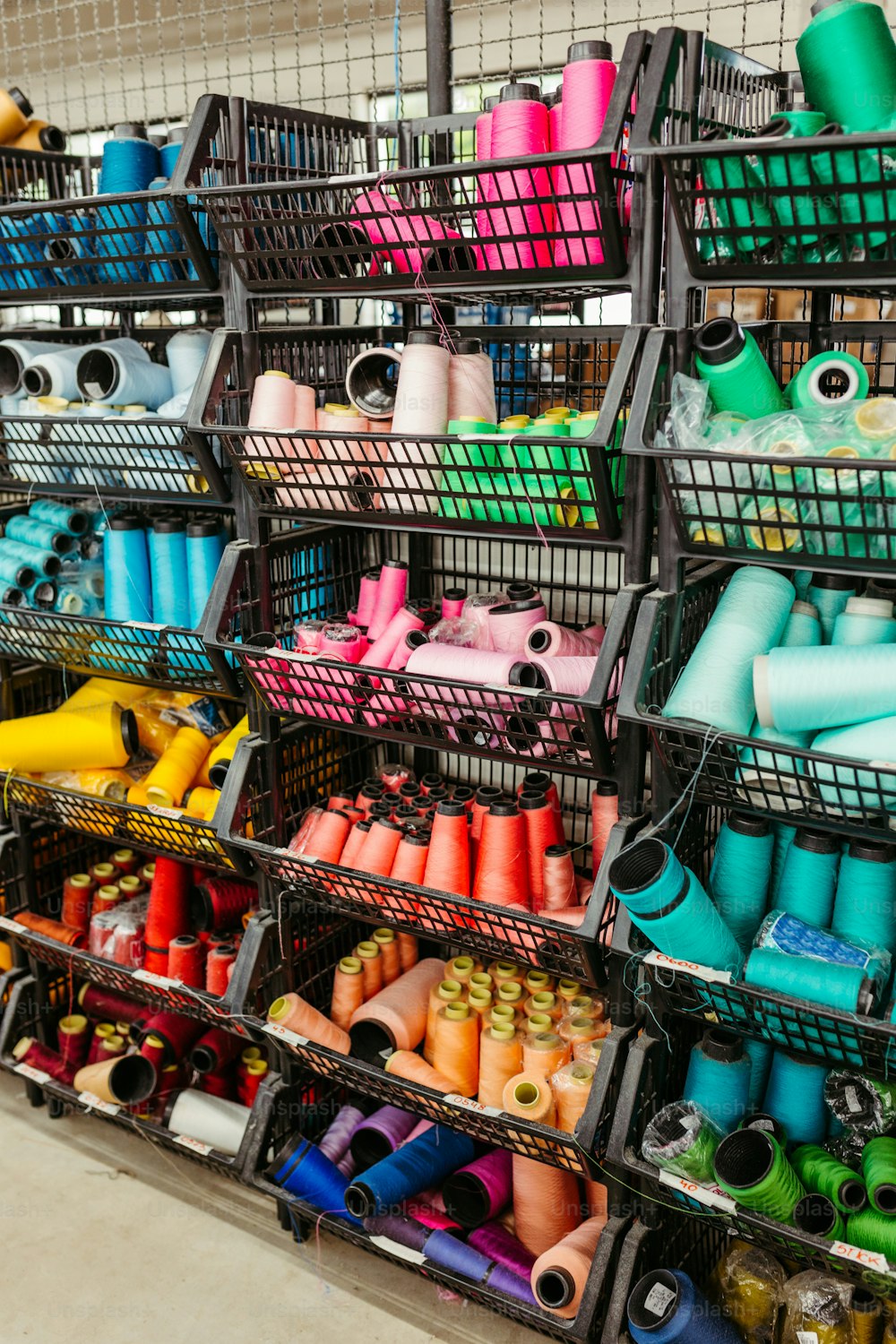 a large display of different colored spools of thread