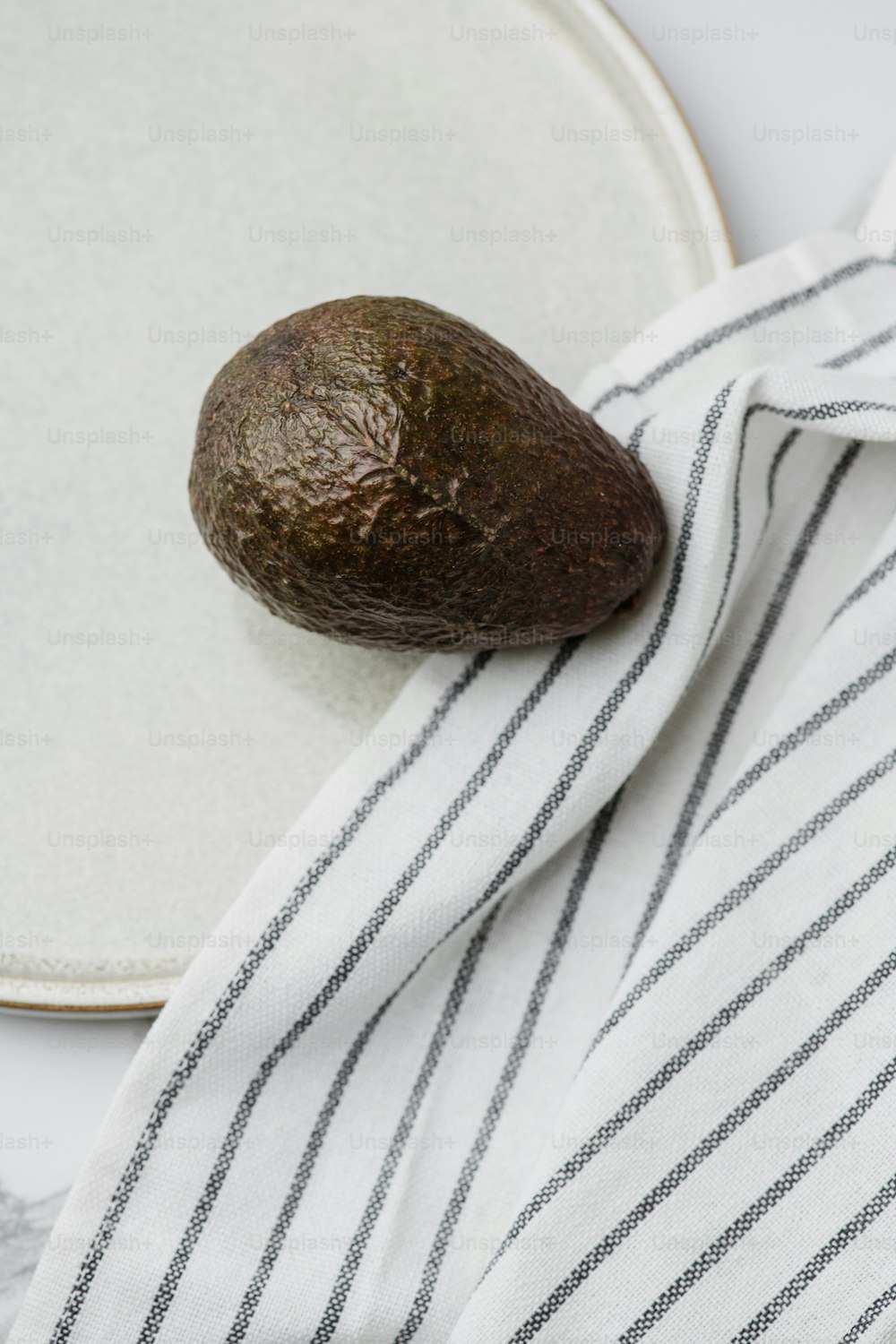 an avocado is sitting on a towel on a plate