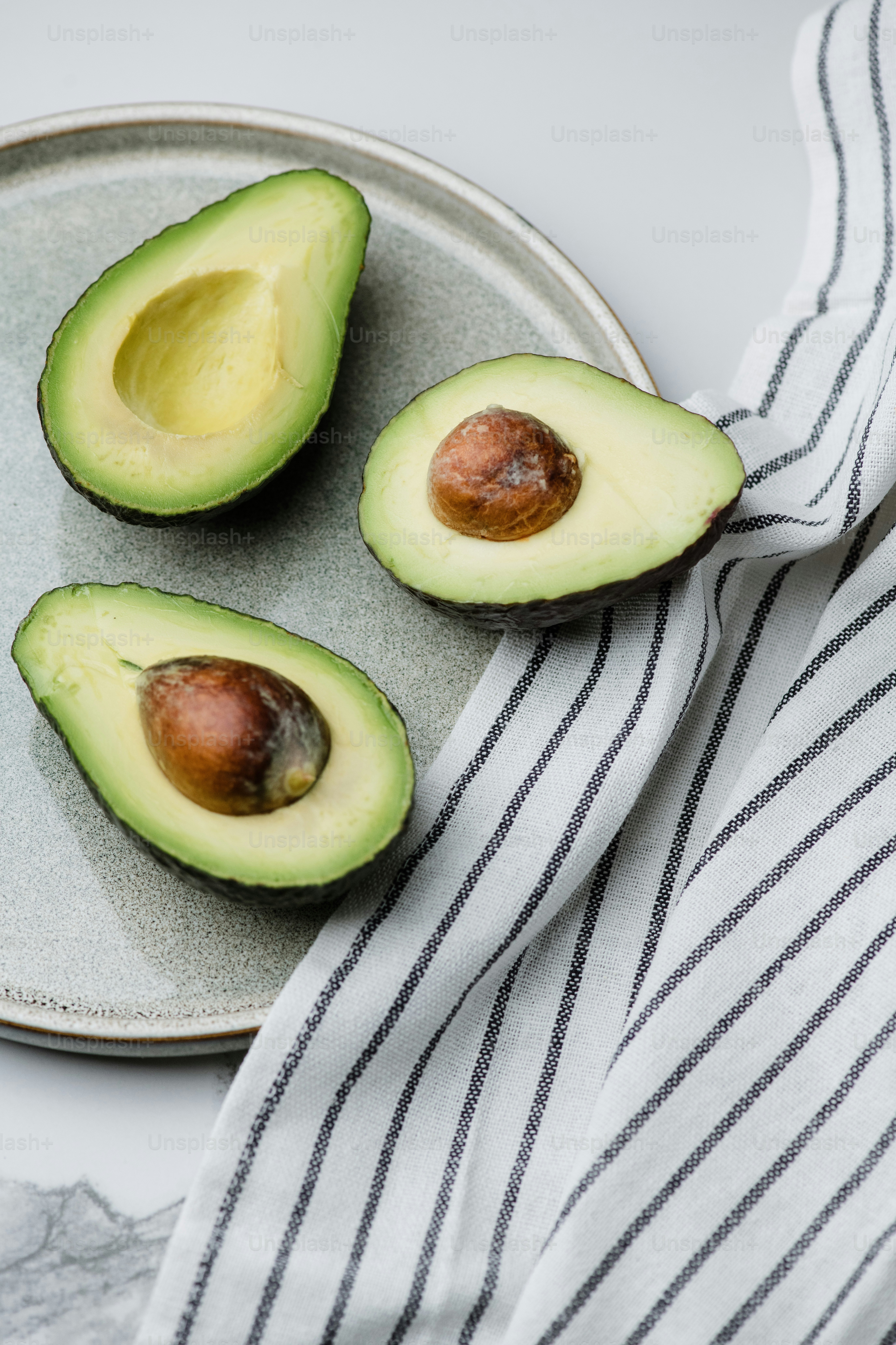 un aguacate cortado por la mitad en un plato