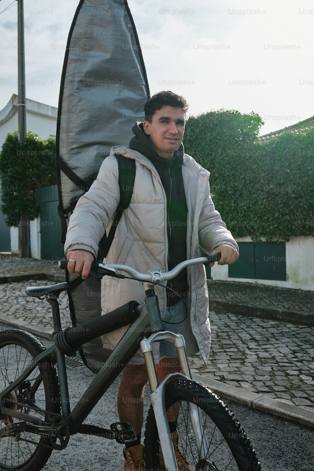a man holding a bike with a surfboard strapped to it