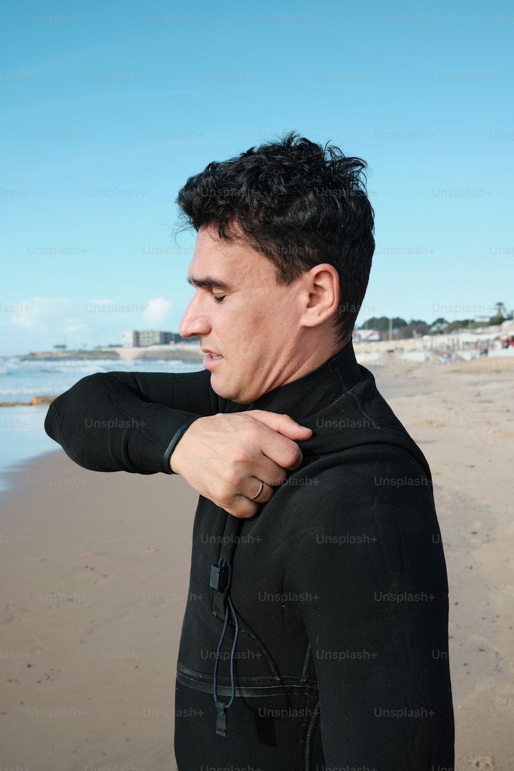 a man in a wet suit standing on a beach