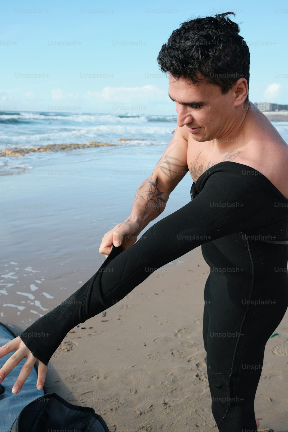 Ein Mann im Neoprenanzug hält sich an einem Surfbrett fest