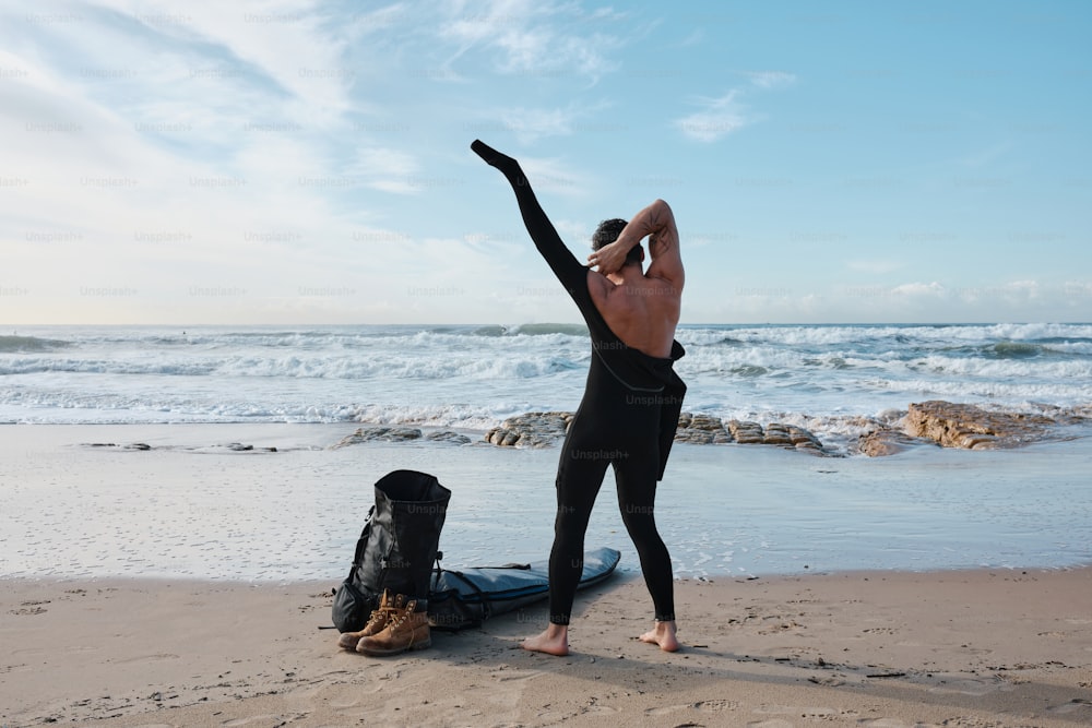 a man doing a handstand on a surfboard on the beach