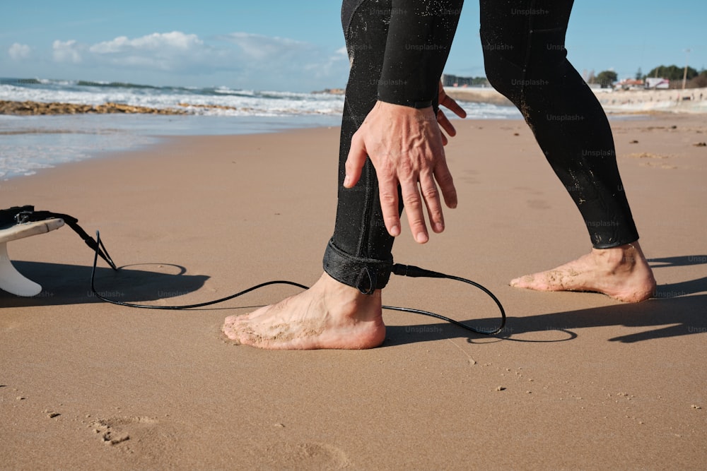 Una persona in piedi su una spiaggia con i piedi nella sabbia