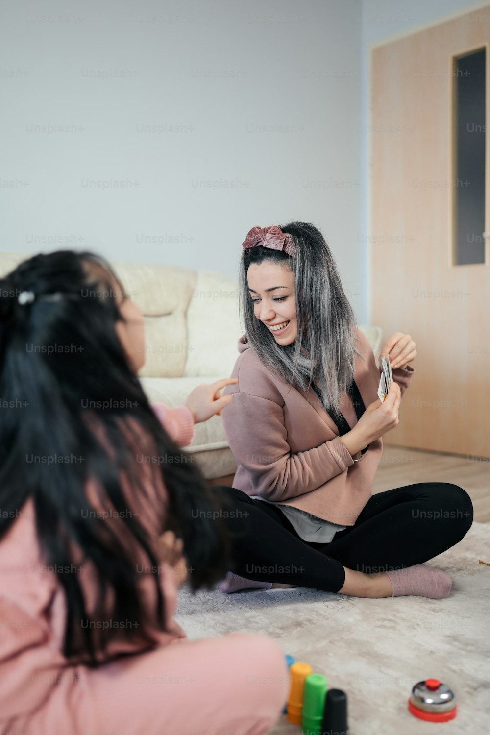 a woman sitting on the floor with her hair in a ponytail