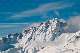 Un uomo che cavalca gli sci lungo il fianco di una montagna innevata