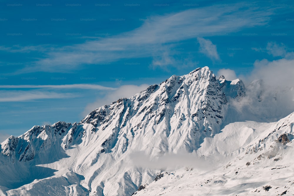 Ein Mann fährt auf Skiern die Seite eines schneebedeckten Berges hinunter