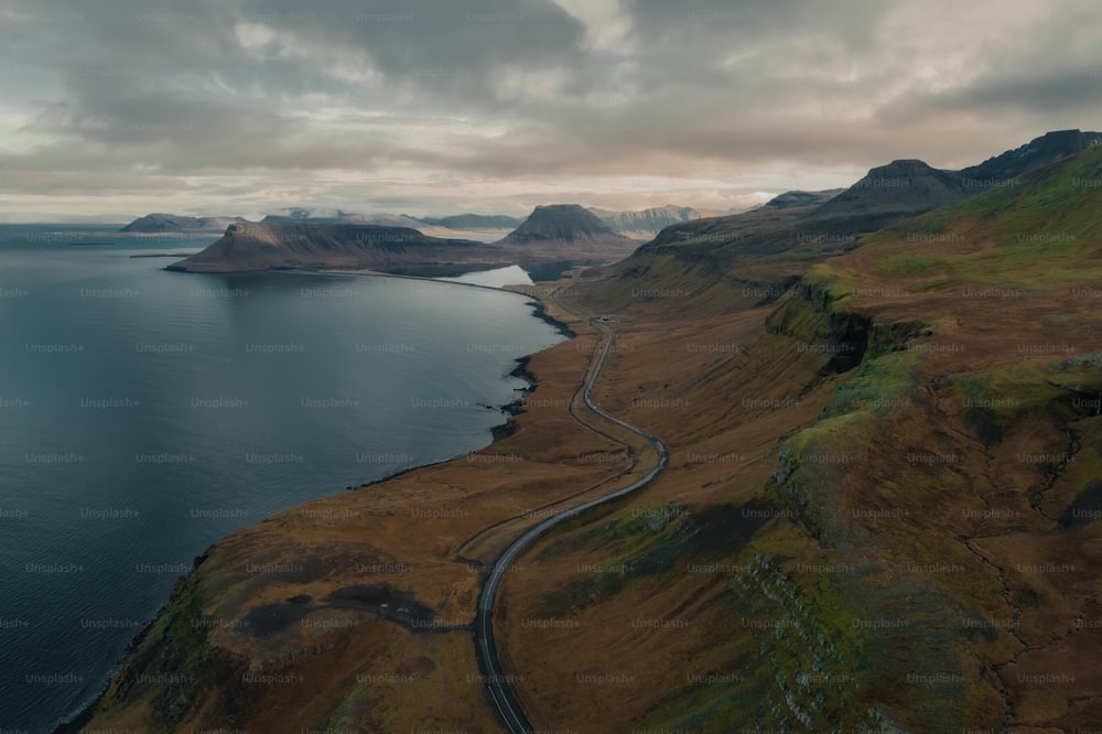 an aerial view of a winding road near a body of water