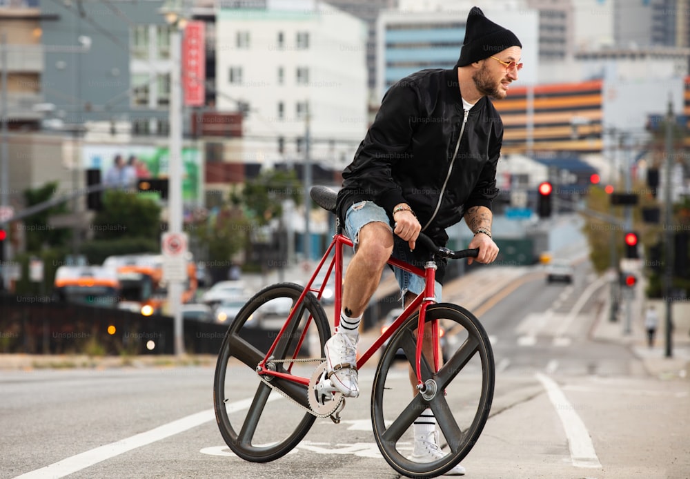 a man riding a red bike down a street