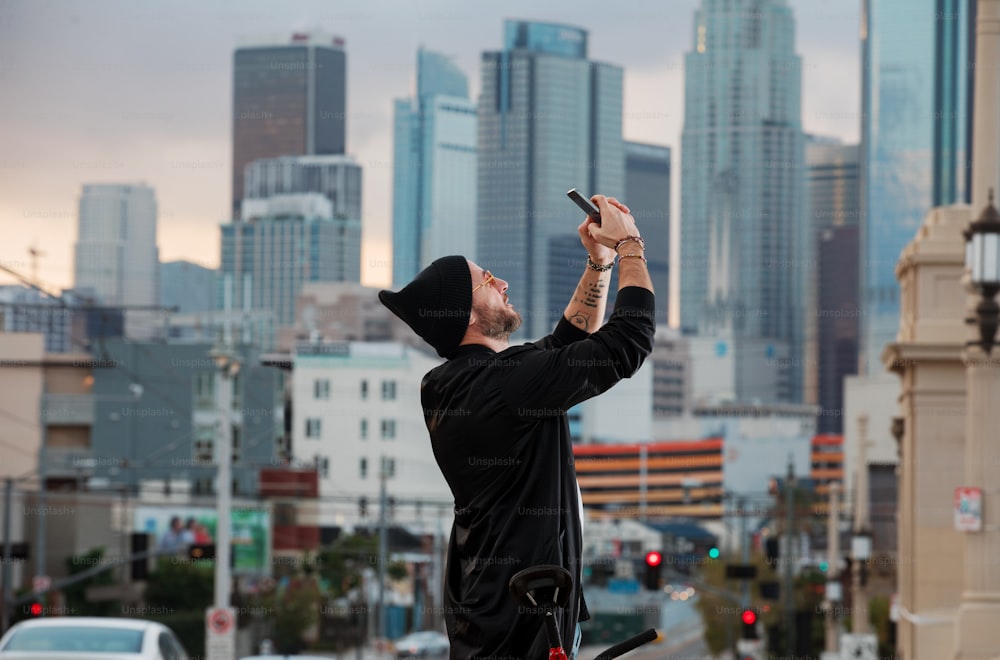 um homem tirando uma foto de uma cidade com seu telefone celular