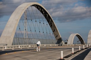 a man riding a bike across a bridge