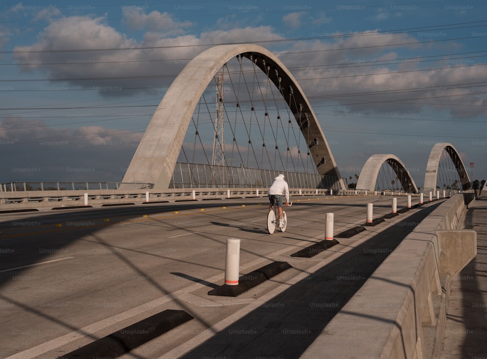 a person riding a bike across a bridge