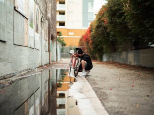 a person kneeling down next to a bike