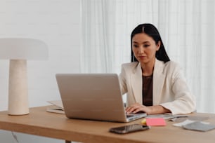 a woman sitting at a desk using a laptop computer