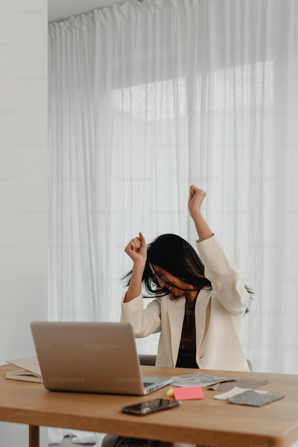 a woman sitting at a table in front of a laptop computer