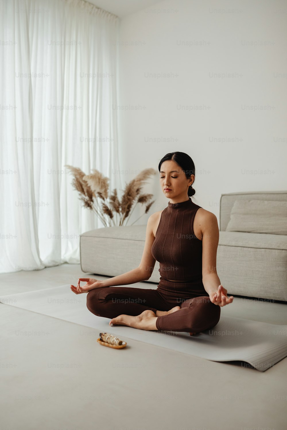 a woman sitting on a yoga mat in a living room