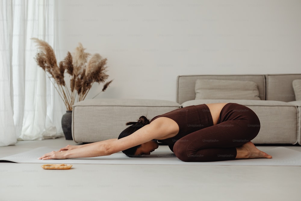 uma mulher está fazendo uma pose de yoga no chão