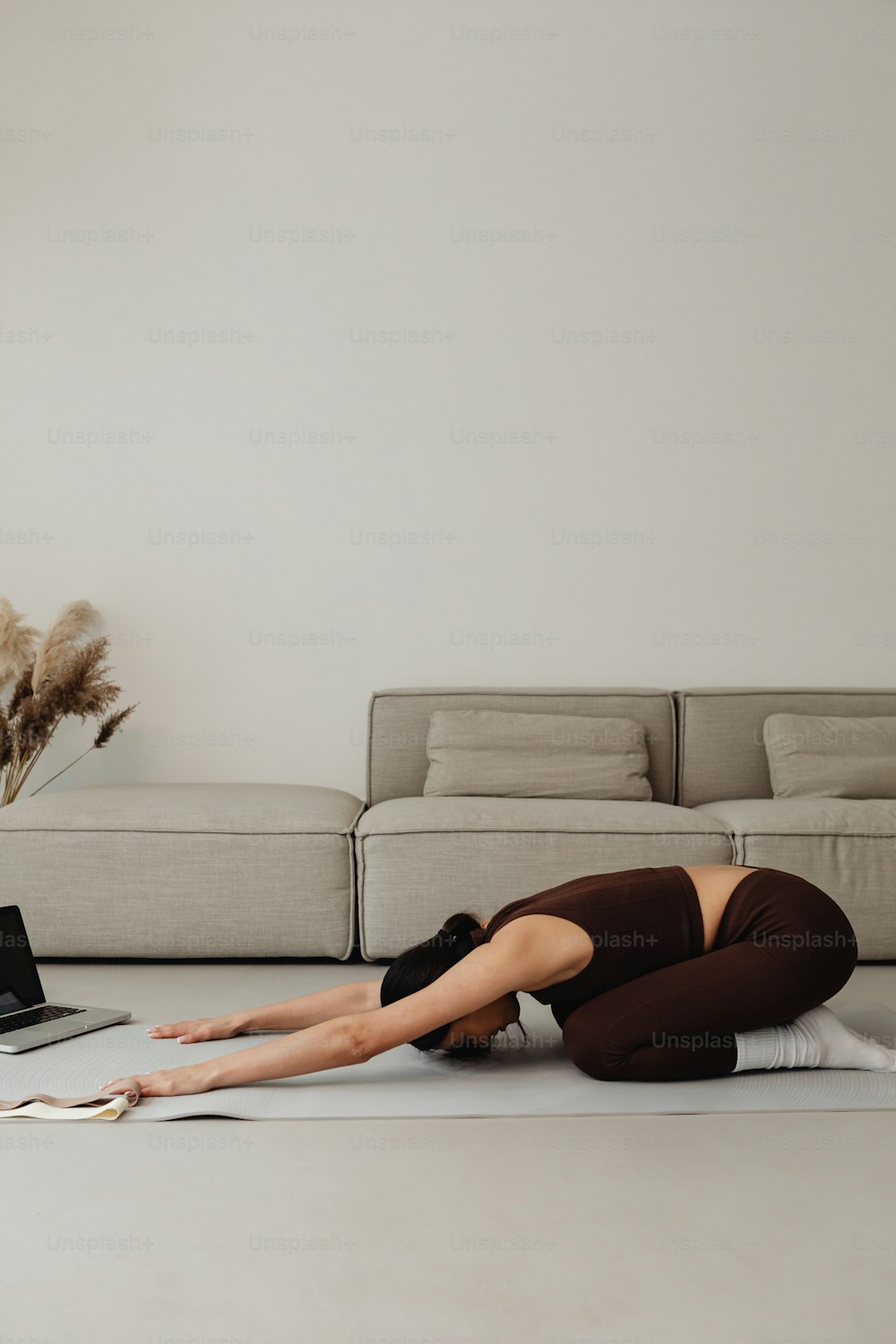 Une femme allongée sur le sol devant un ordinateur portable