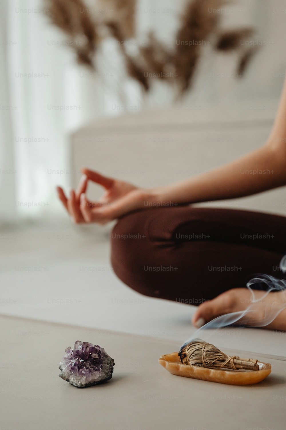 a woman sitting on the floor in front of a rock