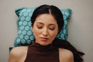 a woman laying down with her eyes closed