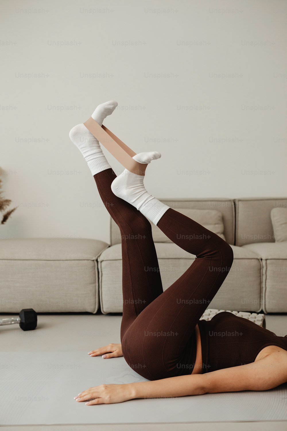 a woman laying on the floor with her legs up